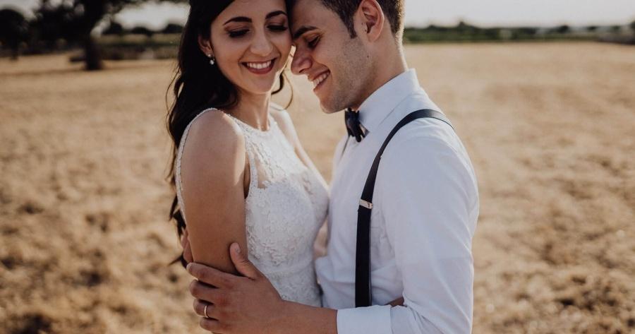 immagine di sposi sorridenti in un campo di grano